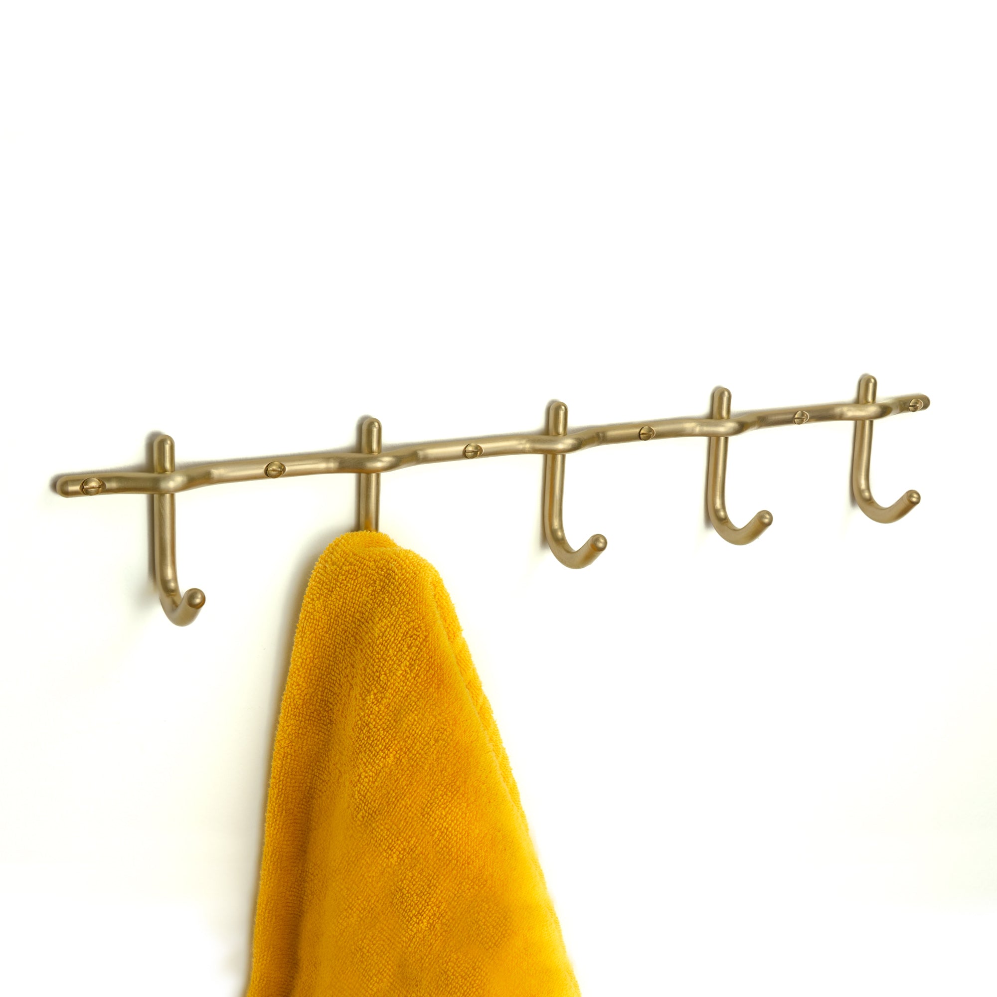 Hand-finished unlacquered brass hook rail, made in Vancouver