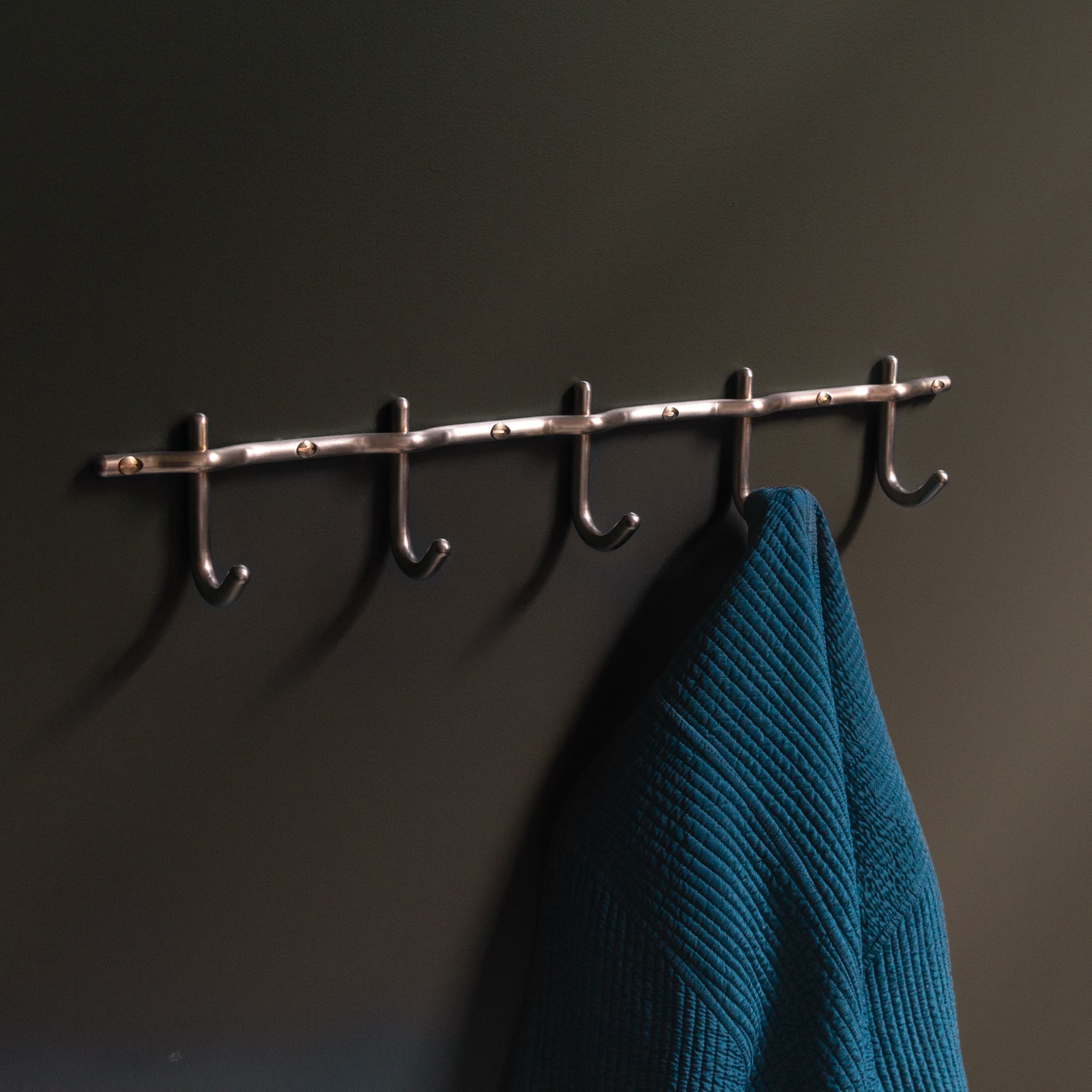 Hand-finished unlacquered brass hook rail, made in Vancouver