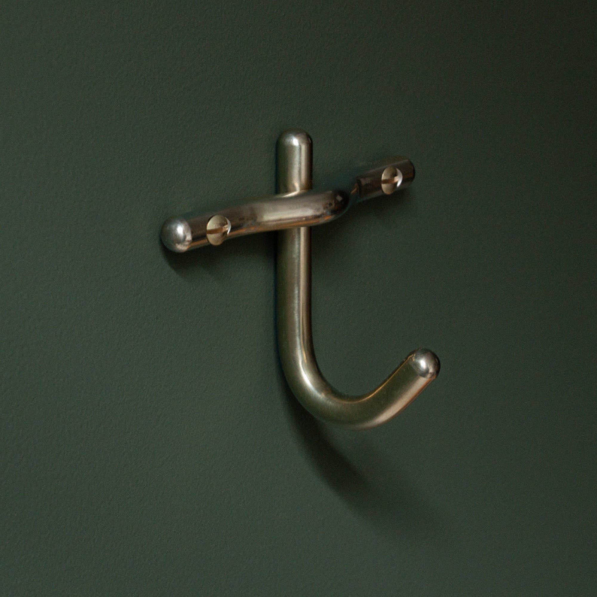 Brass hook on a dark green background